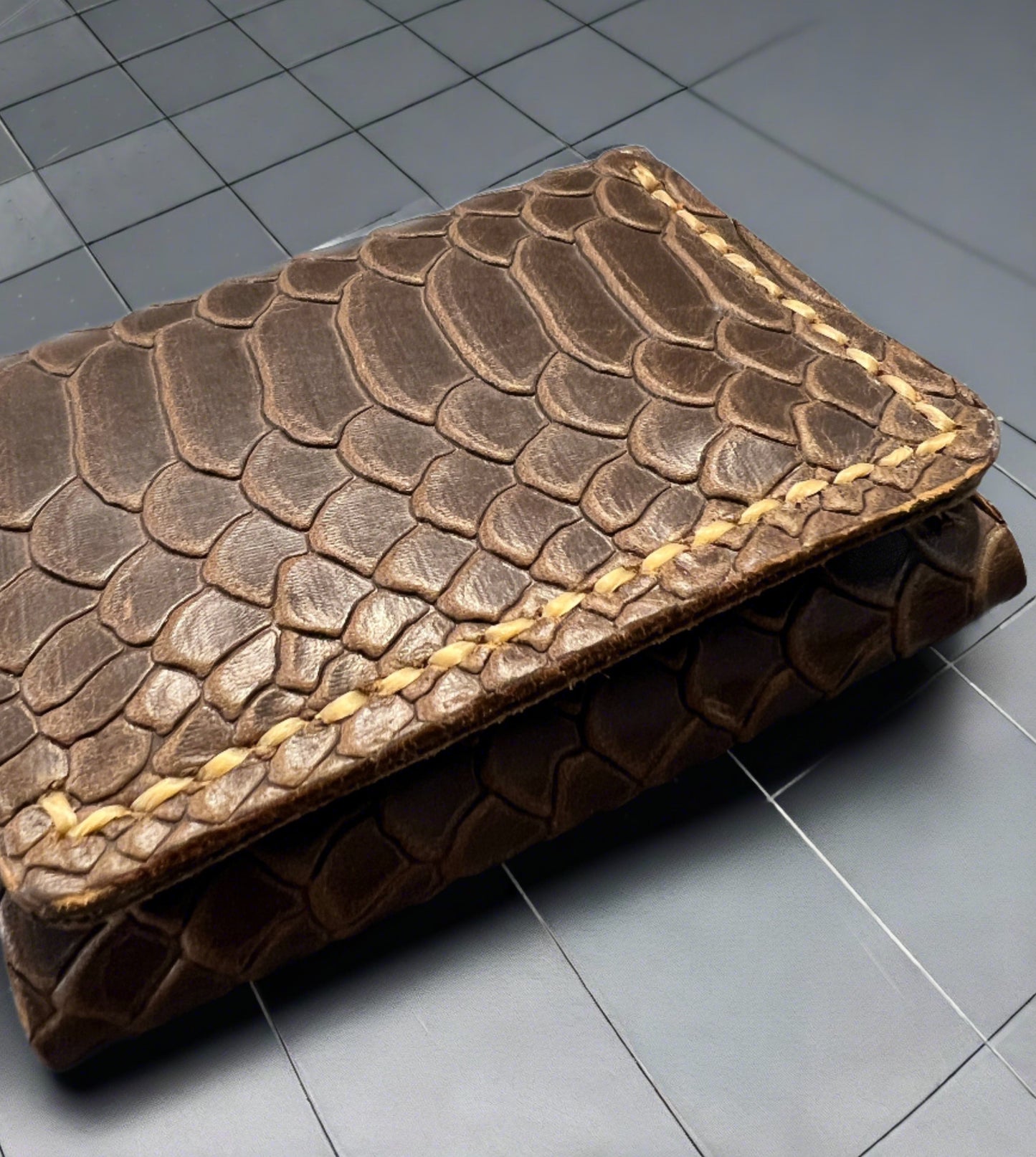 Brown snake embossed leather trifold wallet.